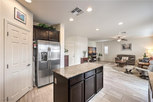 7948 Eastern Elk St, Las Vegas, NV 89149 - kitchen featuring stainless steel fridge with ice dispenser, a ceiling fan, a kitchen island, light stone counters, and open floor plan