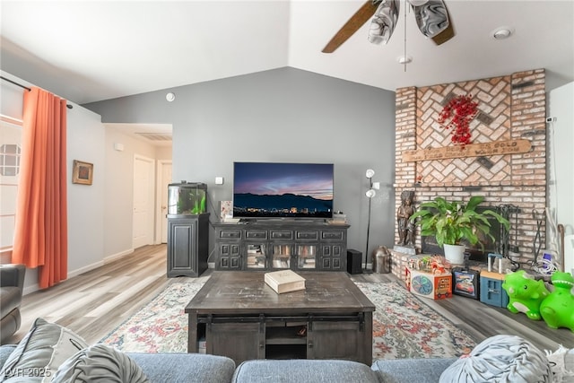 2230 Wagon Ave, Pahrump, NV 89048 - living area featuring a ceiling fan, wood finished floors, vaulted ceiling, and a brick fireplace