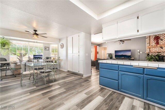 2230 Wagon Ave, Pahrump, NV 89048 - kitchen featuring a ceiling fan, blue cabinets, white cabinets, and open floor plan