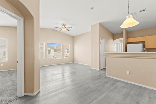 9338 Square Dance Pl Unit 101, Las Vegas, NV 89178 - unfurnished living room with ceiling fan, lofted ceiling, light wood-type flooring, and arched walkways