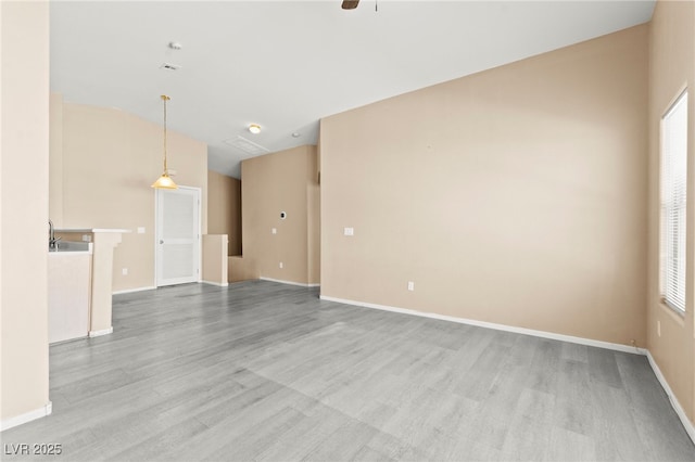 9338 Square Dance Pl Unit 101, Las Vegas, NV 89178 - unfurnished living room with light wood-style flooring, a ceiling fan, plenty of natural light, and vaulted ceiling
