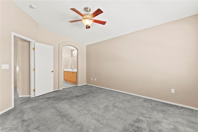 9338 Square Dance Pl Unit 101, Las Vegas, NV 89178 - unfurnished bedroom with carpet flooring, connected bathroom, arched walkways, and a ceiling fan