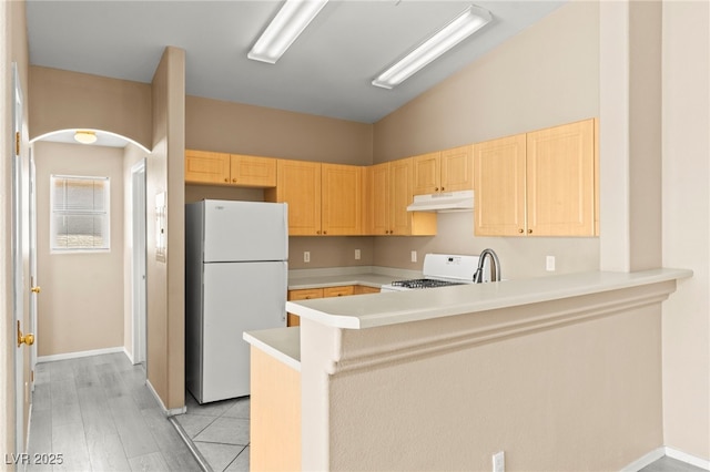 9338 Square Dance Pl Unit 101, Las Vegas, NV 89178 - kitchen featuring freestanding refrigerator, under cabinet range hood, stove, light brown cabinetry, and high vaulted ceiling