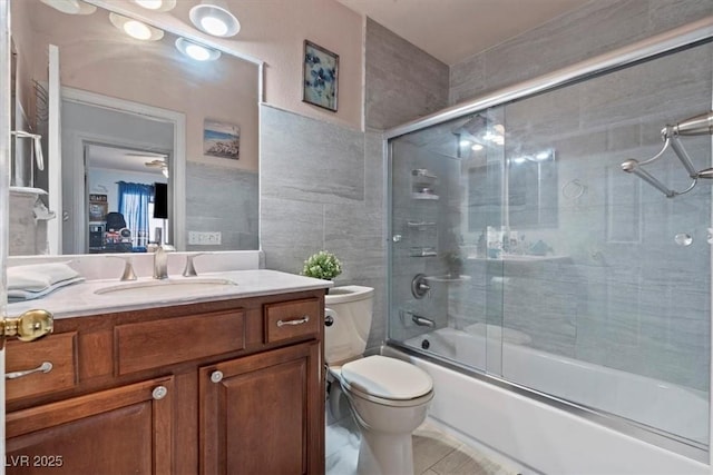 6292 Belgium Dr, Las Vegas, NV 89122 - full bathroom with combined bath / shower with glass door, vanity, tile walls, and tile patterned flooring
