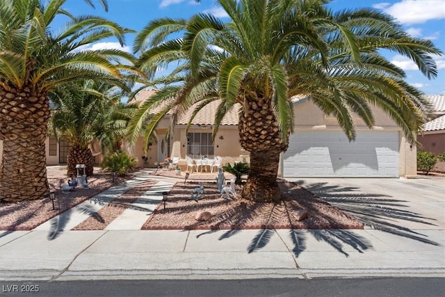 6292 Belgium Dr, Las Vegas, NV 89122 - obstructed view of property with concrete driveway, stucco siding, and a garage