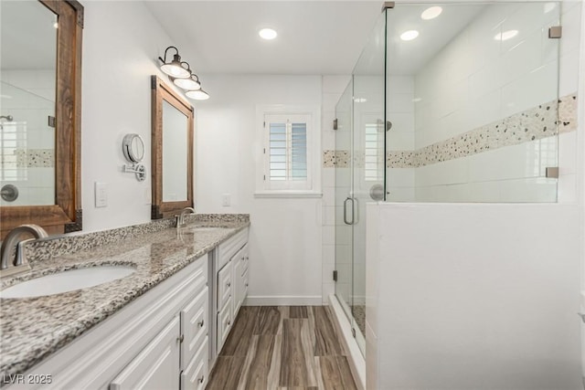 9660 W Ann Rd, Las Vegas, NV 89149 - bathroom with a shower stall, double vanity, wood finished floors, and recessed lighting