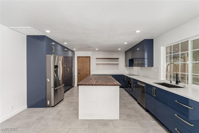 9660 W Ann Rd, Las Vegas, NV 89149 - kitchen with appliances with stainless steel finishes, wood counters, open shelves, blue cabinetry, and a kitchen island