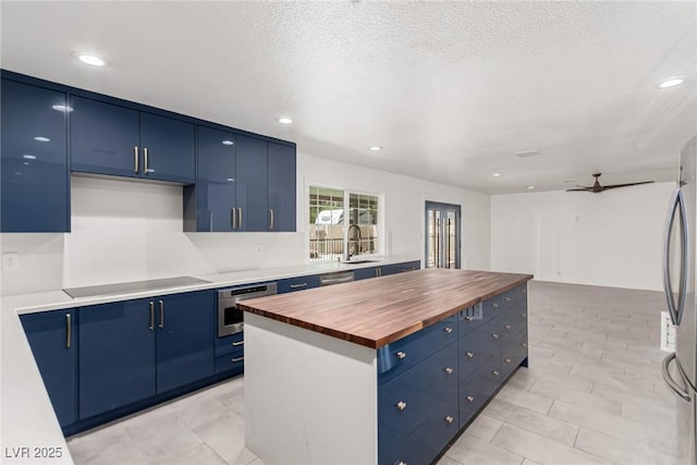 9660 W Ann Rd, Las Vegas, NV 89149 - kitchen featuring appliances with stainless steel finishes, butcher block counters, blue cabinetry, a center island, and recessed lighting
