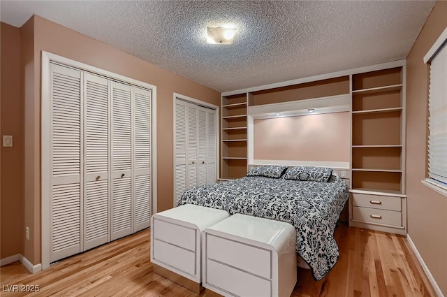 6213 Fairwood Ave, Las Vegas, NV 89107 - bedroom with light wood-style flooring, multiple closets, and a textured ceiling