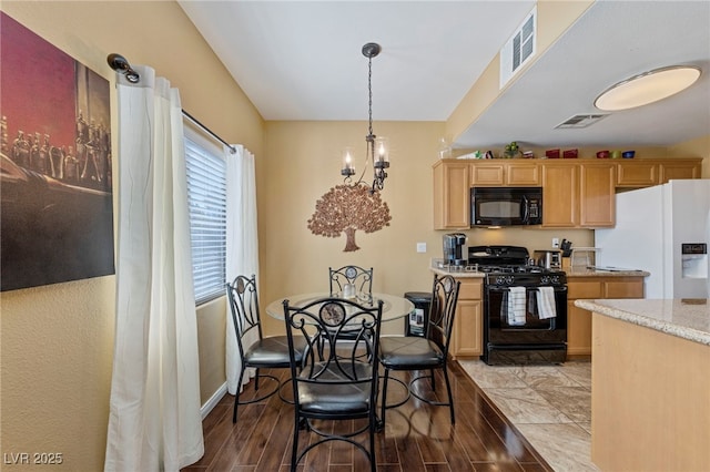 7701 W Robindale Rd Unit 274, Las Vegas, NV 89113 - kitchen featuring black appliances, light brown cabinetry, wood finished floors, and hanging light fixtures
