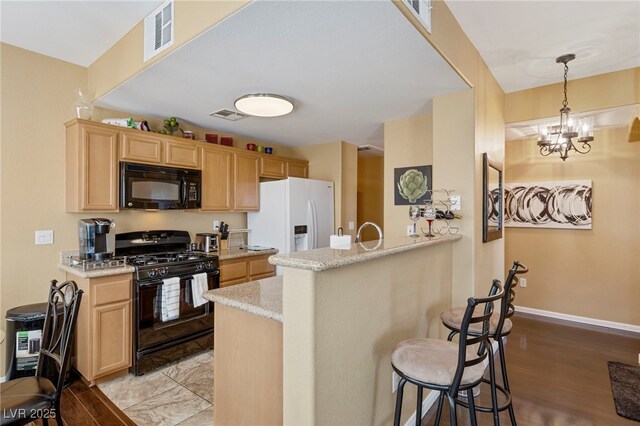 7701 W Robindale Rd Unit 274, Las Vegas, NV 89113 - kitchen with black appliances, a breakfast bar, light brown cabinets, and a peninsula
