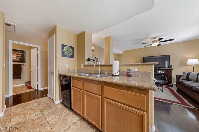7701 W Robindale Rd Unit 274, Las Vegas, NV 89113 - kitchen with black dishwasher, a peninsula, open floor plan, ceiling fan, and light wood-style floors