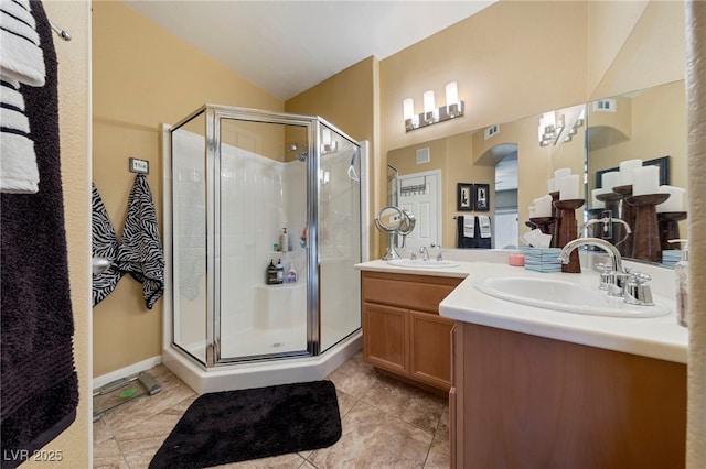 7701 W Robindale Rd Unit 274, Las Vegas, NV 89113 - bathroom with a shower stall, double vanity, tile patterned flooring, and vaulted ceiling