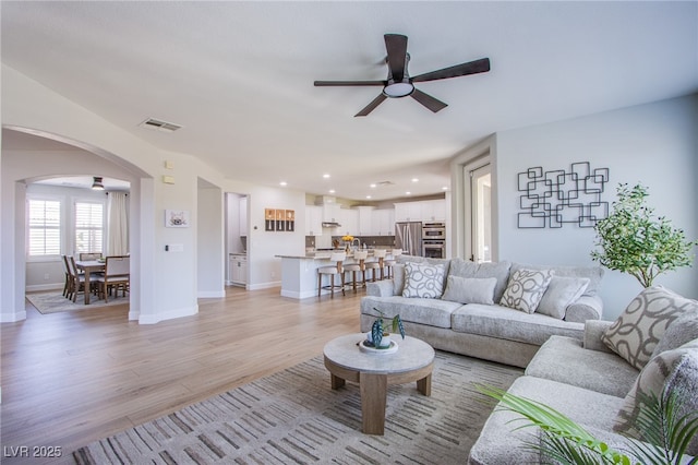7445 Mezzanine View Ave, Las Vegas, NV 89178 - living area featuring ceiling fan, arched walkways, light wood-style flooring, and recessed lighting