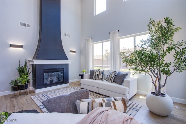 7445 Mezzanine View Ave, Las Vegas, NV 89178 - living room with a high ceiling, wood finished floors, and a fireplace