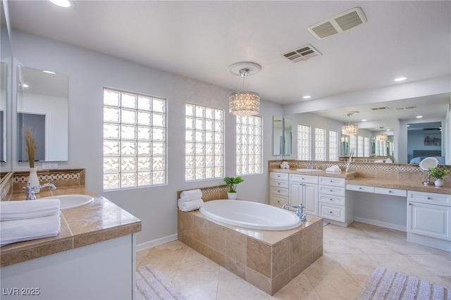 7445 Mezzanine View Ave, Las Vegas, NV 89178 - bathroom with a chandelier, two vanities, a garden tub, tile patterned flooring, and recessed lighting