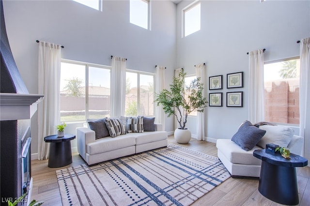 7445 Mezzanine View Ave, Las Vegas, NV 89178 - living room with a towering ceiling, wood finished floors, and a fireplace