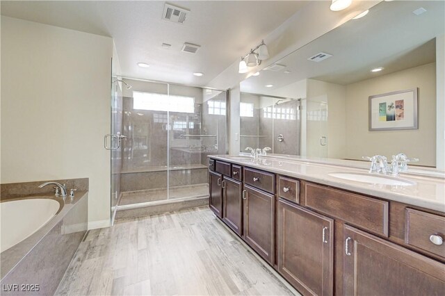 8565 Silver Coast St, Las Vegas, NV 89139 - full bath with double vanity, a garden tub, a shower stall, and wood finished floors