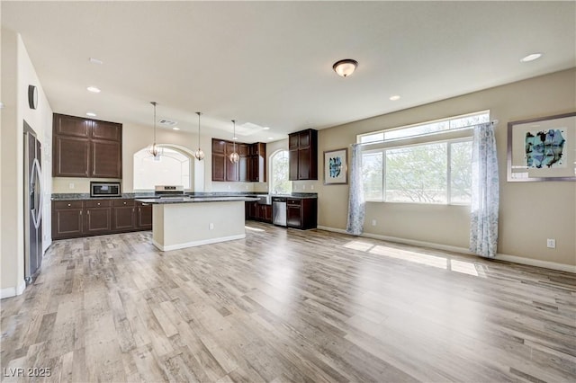 8565 Silver Coast St, Las Vegas, NV 89139 - kitchen featuring appliances with stainless steel finishes, light wood finished floors, dark brown cabinetry, recessed lighting, and a center island