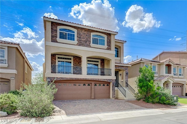 8565 Silver Coast St, Las Vegas, NV 89139 - view of front of home featuring stone siding, a balcony, stucco siding, and an attached garage
