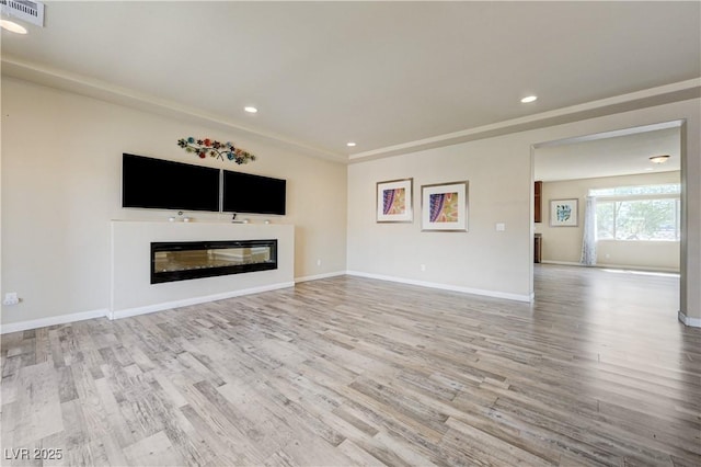 8565 Silver Coast St, Las Vegas, NV 89139 - unfurnished living room featuring wood finished floors, a glass covered fireplace, and recessed lighting