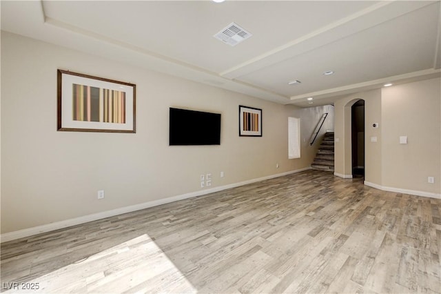 8565 Silver Coast St, Las Vegas, NV 89139 - spare room with a tray ceiling, arched walkways, light wood-type flooring, stairway, and recessed lighting