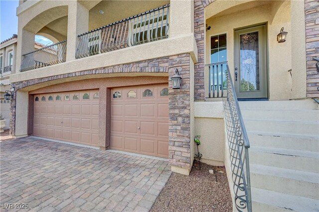 8565 Silver Coast St, Las Vegas, NV 89139 - entrance to property featuring a garage, decorative driveway, stone siding, and stucco siding