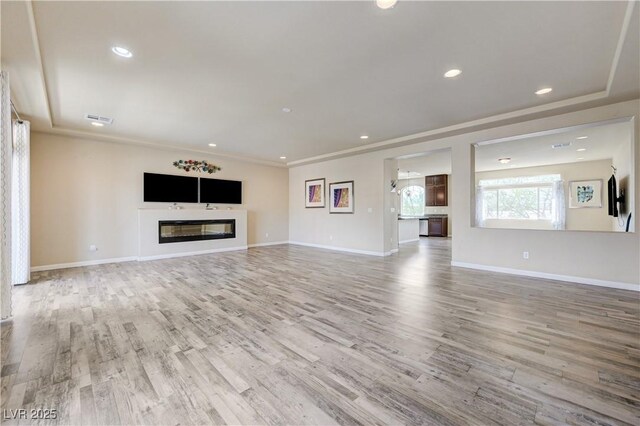 8565 Silver Coast St, Las Vegas, NV 89139 - unfurnished living room with wood finished floors, a glass covered fireplace, and recessed lighting