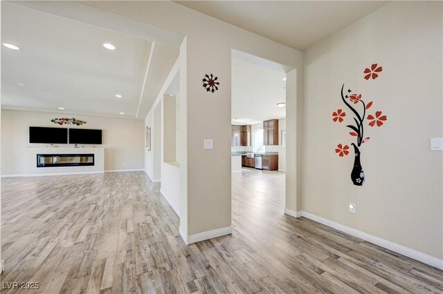 8565 Silver Coast St, Las Vegas, NV 89139 - unfurnished living room featuring light wood-style flooring, a glass covered fireplace, and recessed lighting