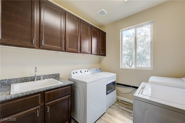 8565 Silver Coast St, Las Vegas, NV 89139 - laundry area featuring washer and dryer, cabinet space, and light wood-style flooring
