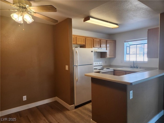2986 Juniper Hills Blvd Unit 202, Las Vegas, NV 89142 - kitchen featuring white appliances, under cabinet range hood, wood finished floors, a peninsula, and a ceiling fan