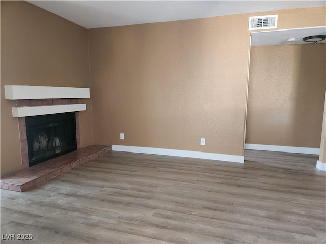 2986 Juniper Hills Blvd Unit 202, Las Vegas, NV 89142 - unfurnished living room featuring wood finished floors and a tile fireplace