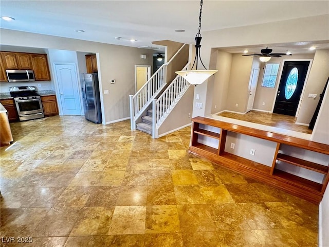 5361 Candlespice Way, Las Vegas, NV 89135 - kitchen with stainless steel appliances, brown cabinets, a ceiling fan, and hanging light fixtures