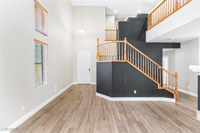 3405 Brook Song Ave, North Las Vegas, NV 89081 - unfurnished living room with stairway, wood finished floors, and a towering ceiling