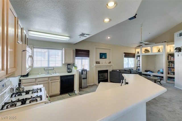 2925 Wigwam Pkwy Unit 1124, Henderson, NV 89074 - kitchen with black dishwasher, white microwave, light colored carpet, a tile fireplace, and plenty of natural light