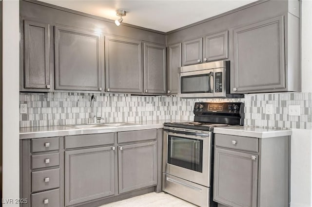 1708 Cedar Ave, Las Vegas, NV 89101 - kitchen featuring appliances with stainless steel finishes, gray cabinets, light countertops, and decorative backsplash