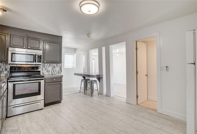 1708 Cedar Ave, Las Vegas, NV 89101 - kitchen featuring stainless steel appliances, tasteful backsplash, and light wood-style floors