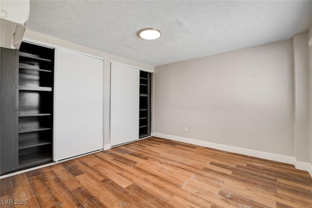 1708 Cedar Ave, Las Vegas, NV 89101 - unfurnished bedroom with wood finished floors, a textured ceiling, and multiple closets