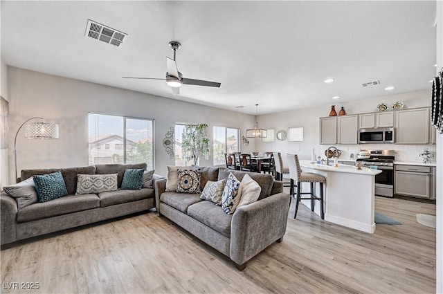 5220 Melbourne Ridge Ct, Las Vegas, NV 89141 - living area featuring light wood-type flooring, ceiling fan, a chandelier, and recessed lighting