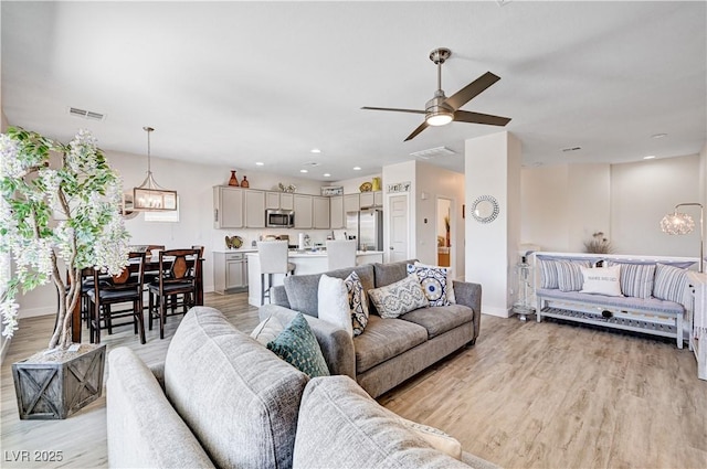 5220 Melbourne Ridge Ct, Las Vegas, NV 89141 - living area with light wood-style floors, a ceiling fan, a chandelier, and recessed lighting