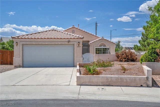 5139 Zapata Ln, North Las Vegas, NV 89031 - view of front of property featuring a tile roof, stucco siding, concrete driveway, a garage, and a gate