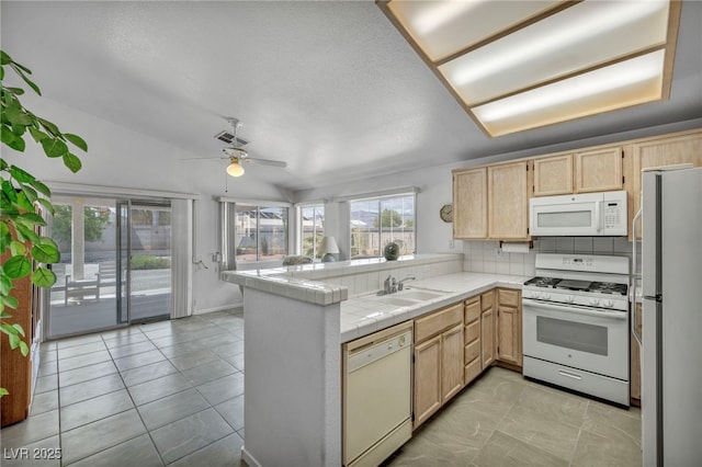 5139 Zapata Ln, North Las Vegas, NV 89031 - kitchen with white appliances, light brown cabinetry, a peninsula, tile countertops, and ceiling fan