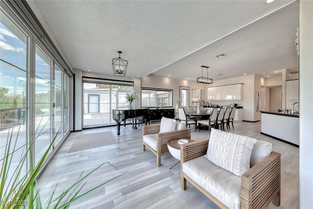 5438 Sierra Brook Ct, Las Vegas, NV 89149 - living area featuring a textured ceiling, light wood-type flooring, and recessed lighting