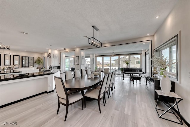 5438 Sierra Brook Ct, Las Vegas, NV 89149 - dining area featuring light wood-style flooring, a textured ceiling, and recessed lighting