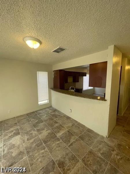 1745 Starridge Way, Las Vegas, NV 89142 - kitchen featuring a textured ceiling and dark countertops
