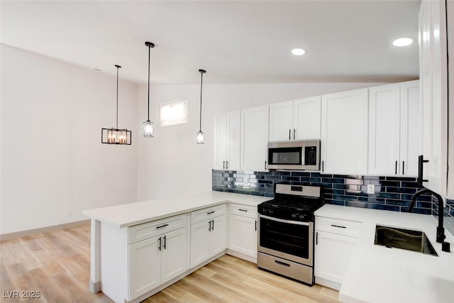 116 Lotus Blossom Ct, Las Vegas, NV 89145 - kitchen with stainless steel appliances, vaulted ceiling, a peninsula, tasteful backsplash, and white cabinets