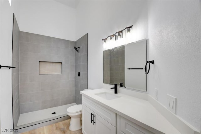 116 Lotus Blossom Ct, Las Vegas, NV 89145 - bathroom with a tile shower, vanity, wood finished floors, and a textured wall
