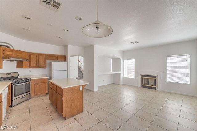 7977 Blue Brook Dr, Las Vegas, NV 89147 - kitchen featuring stainless steel gas range oven, freestanding refrigerator, light countertops, light tile patterned floors, and recessed lighting