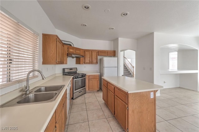 7977 Blue Brook Dr, Las Vegas, NV 89147 - kitchen featuring stainless steel gas range oven, under cabinet range hood, light tile patterned floors, a center island, and recessed lighting