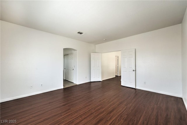 7977 Blue Brook Dr, Las Vegas, NV 89147 - unfurnished bedroom with arched walkways, dark wood-type flooring, and a closet